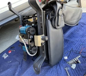 Tap the two holes on the black metal frame, door-side of the passenger chair of the Jeep Wrangler JK.